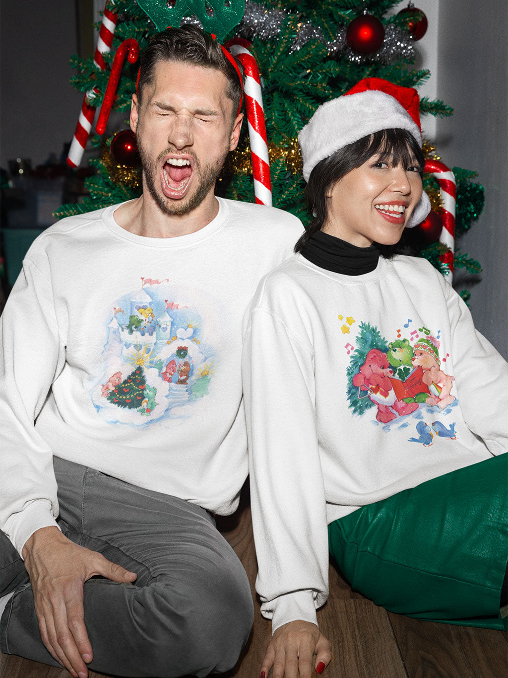 A young couple wearing Classic Care Bears Christmas Sweatshirts