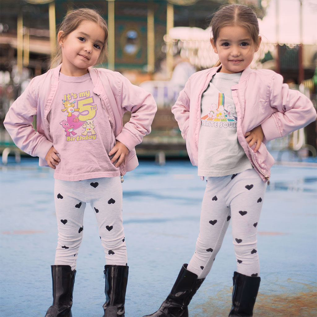 Two young girls wearing official Care Bears t-shirts